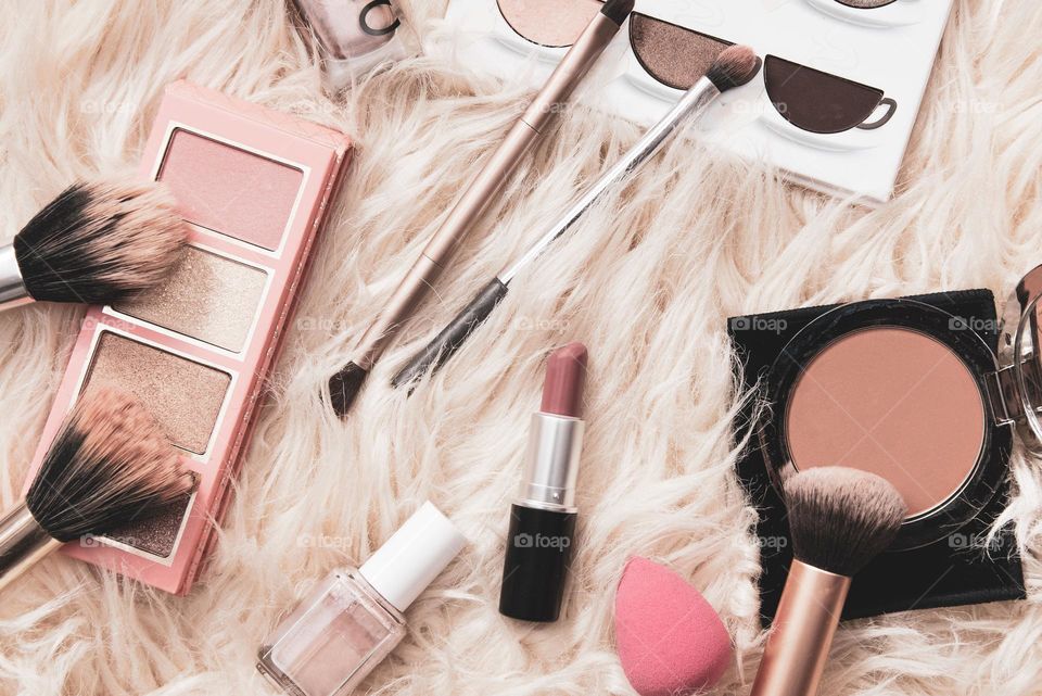Flat lay photo of make-up products on fluffy background
