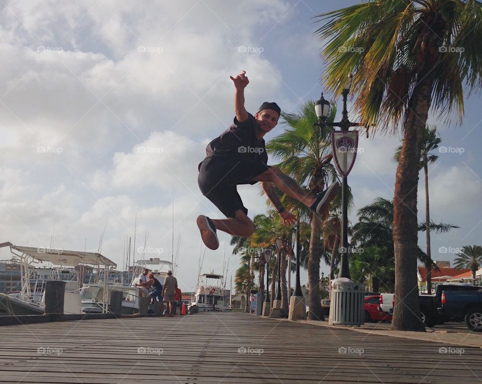 Young man jumping on boardwalk