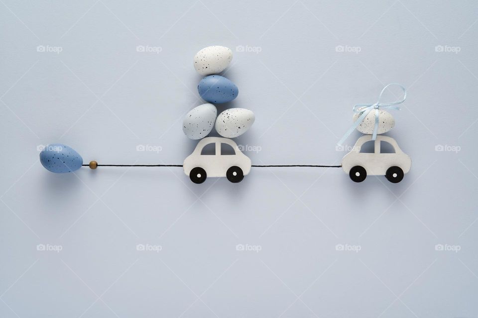 White cars with Easter eggs on a light blue background 