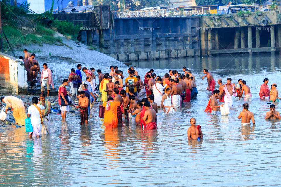 KOLKATA, INDIA - JANUARY 14, 2016: India family taking a bath on the water of Ganges during Kumbh Mela. Ganges water not even suitable for bathing, many toxic materials found: Report