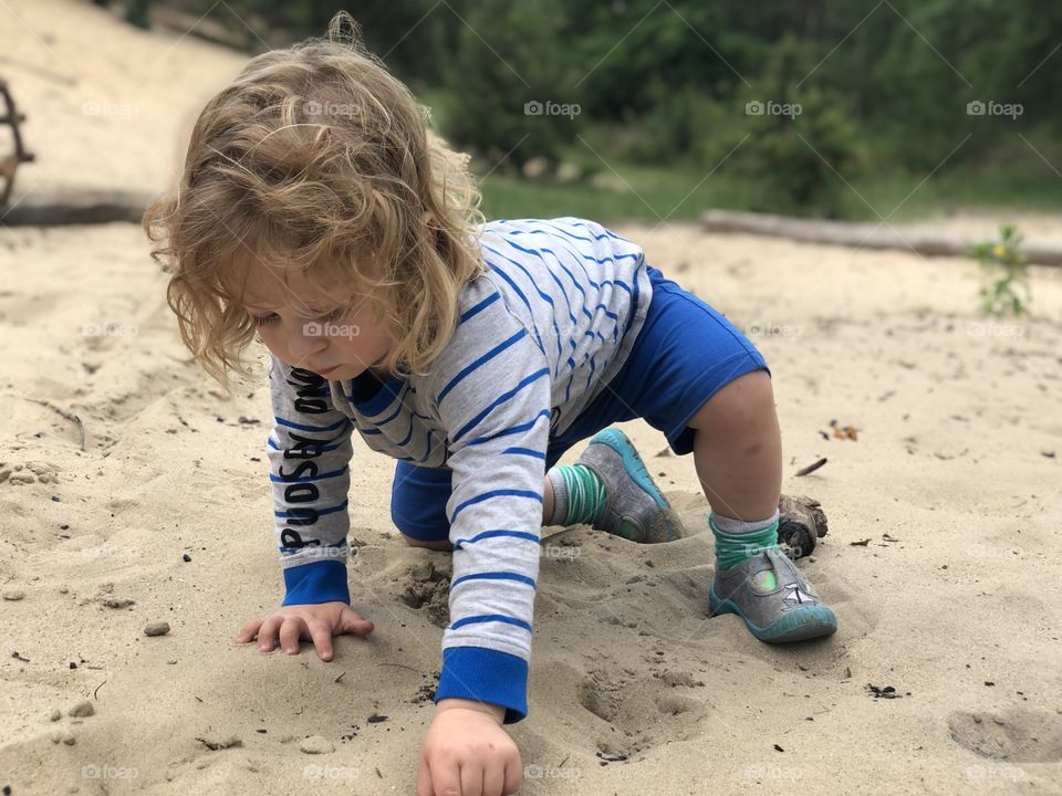 Litle boy playing in the sand 