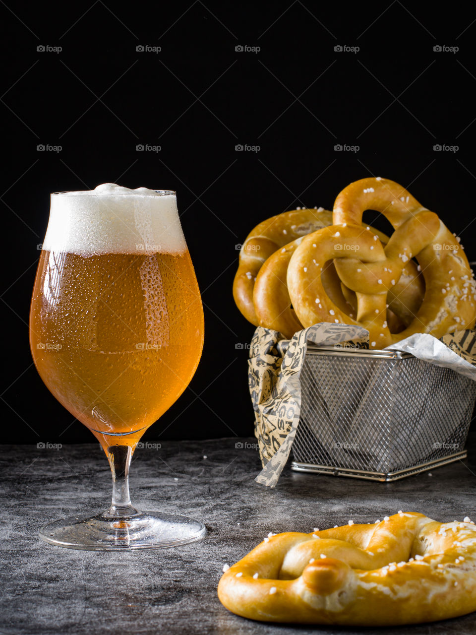 A glass of beer with fresh baked pretzels