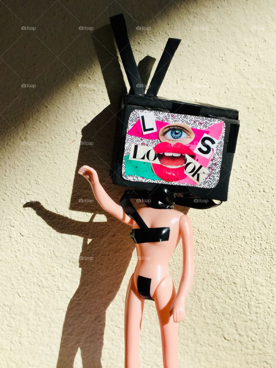 “The Programmed Human Being”. This is a piece of art I created using a plastic doll and replacing the head with a TV set made from foam. The message is how TV programs our minds, making us to look at world through distortion. 