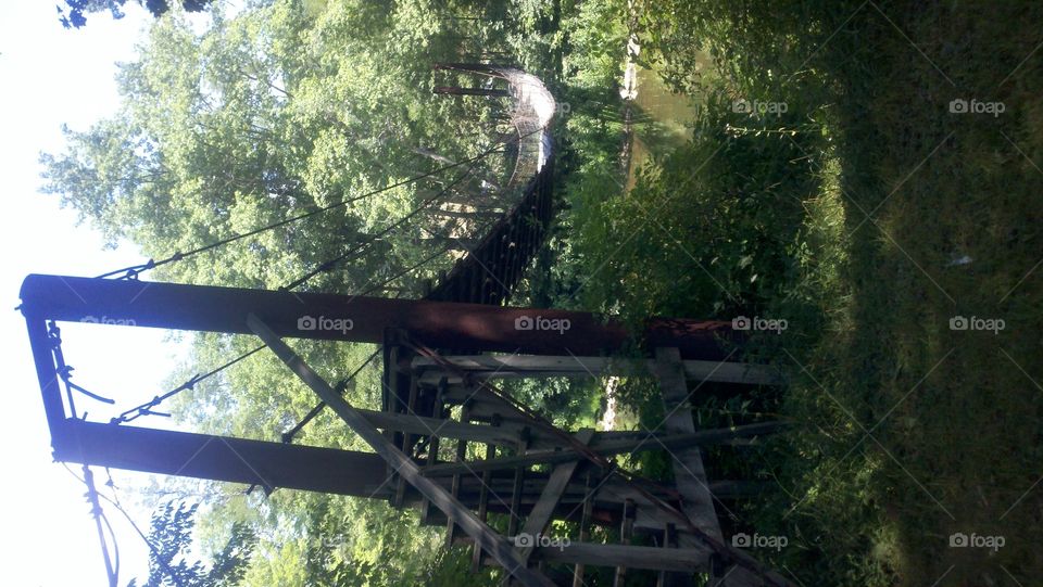 Trod Carefully. An old, rickety swinging bridge over the beginning of the New River in West Virginia