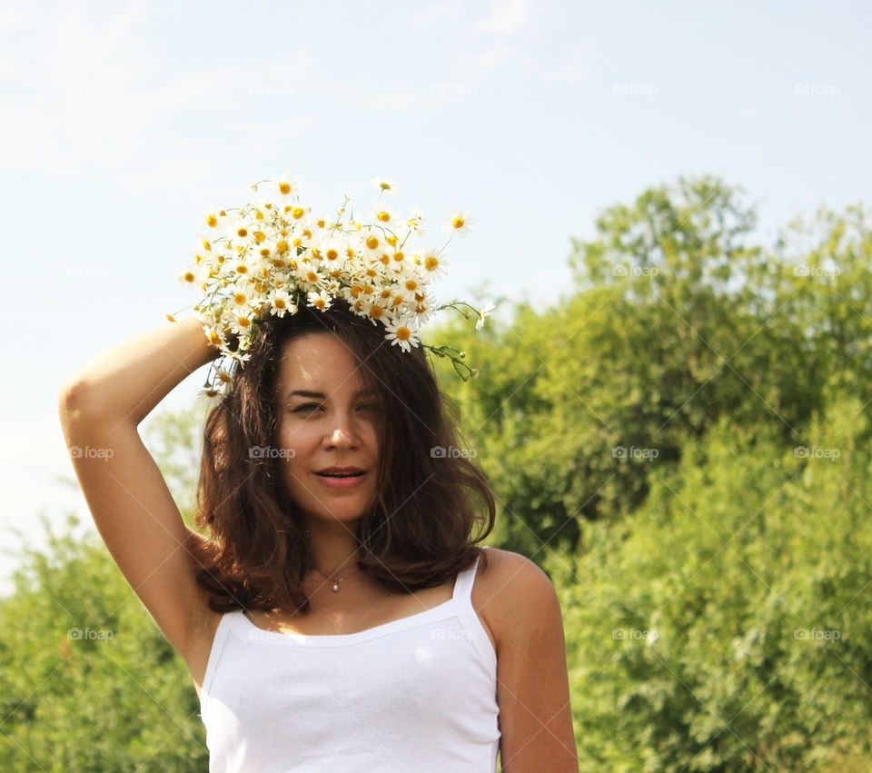 Summer camomiles on young lady's head.
