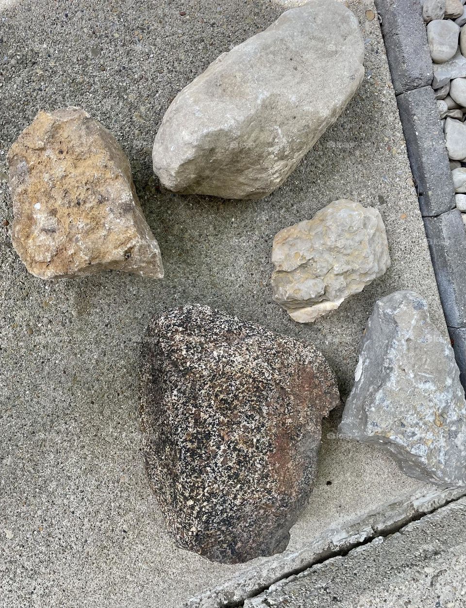 Large rocks on sidewalk, rocks for landscaping projects, landscape rocks, using rocks to decorate 