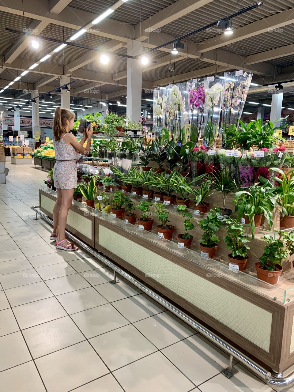 young photographer takes pictures on the camera phone in the store