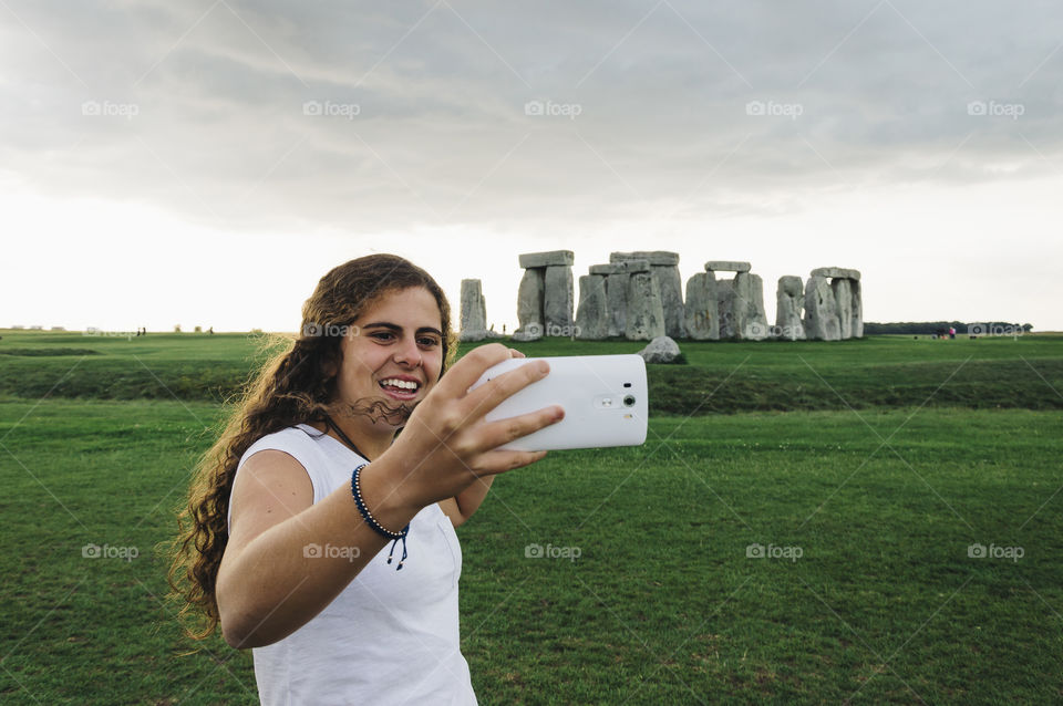 Smiling young woman taking a selfie in Stonehenge