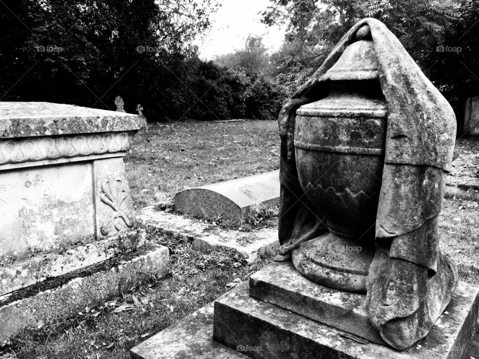 Gothic grave yard in black and white with gravestone and stone carving
