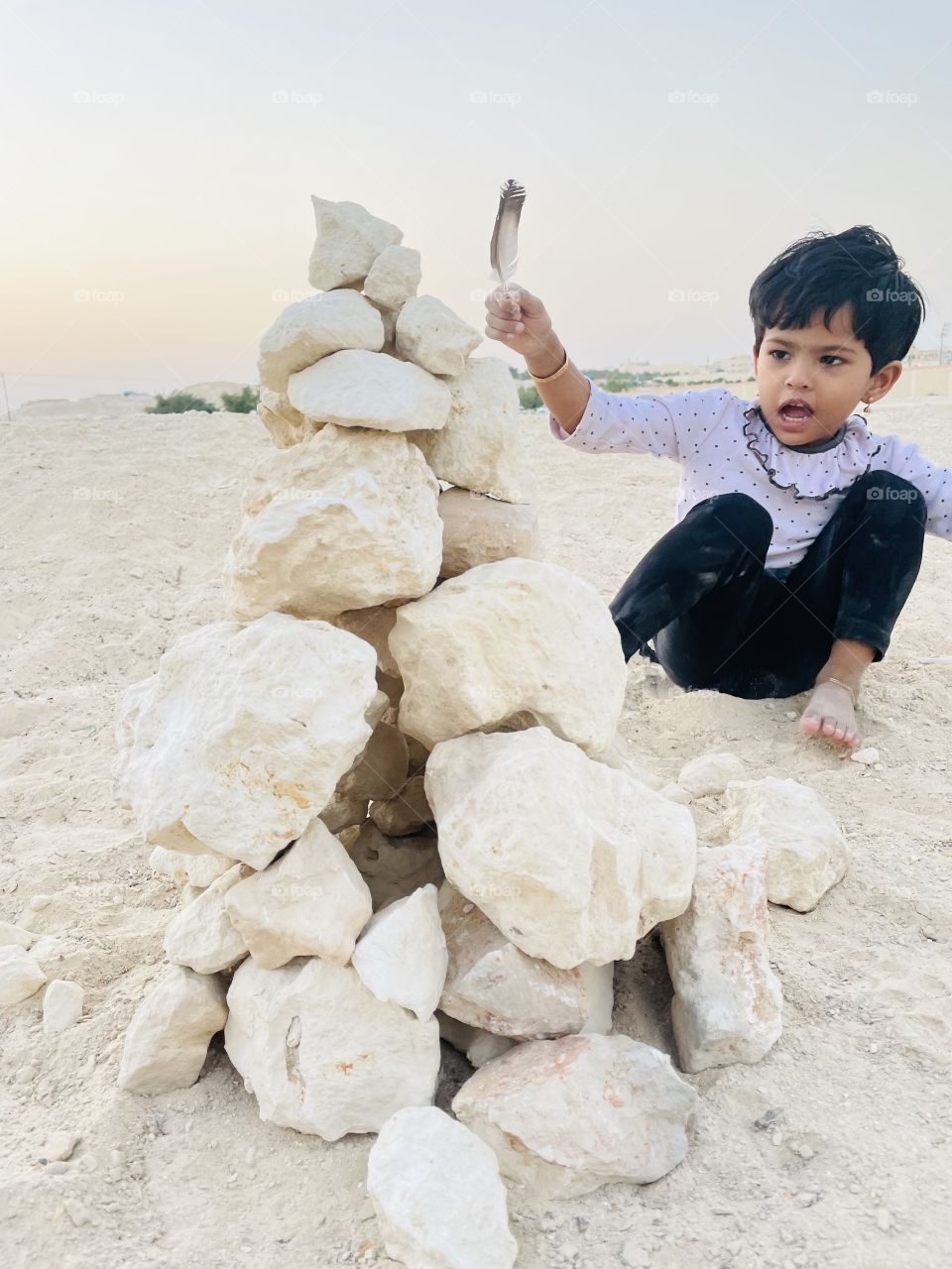 A child having feather on the hand building home
