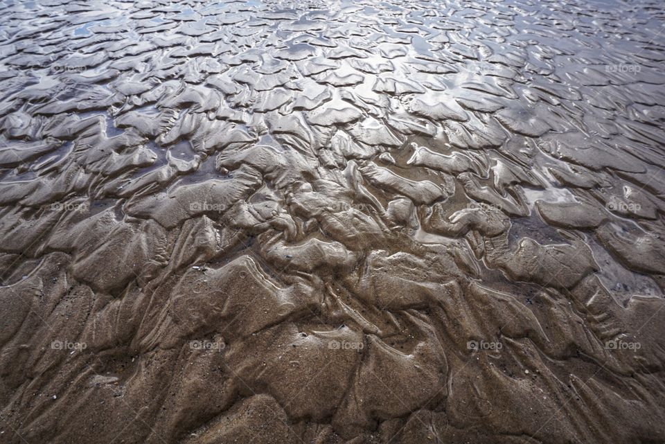 Low Tide .. ripples in the sand made by waves as the tide recedes 