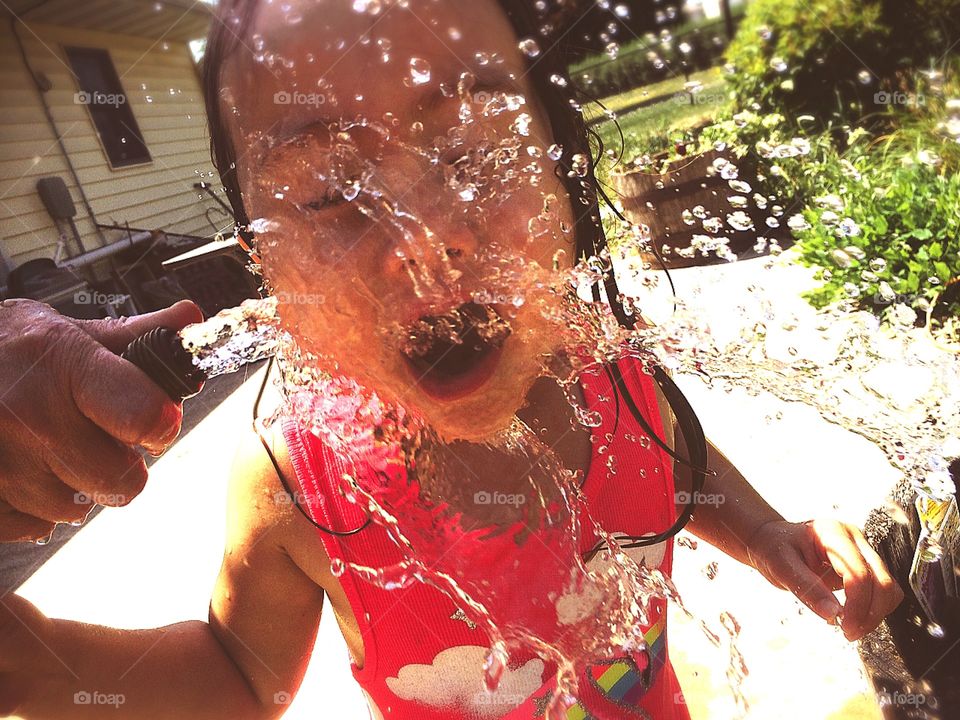 Kylie playing with the garden hose hose