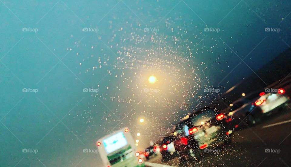 Raindrops on the car window in the traffic 