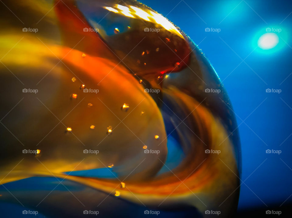 I captured this image during an experimental photo shoot. I wanted to try and use the light from a NOVA Flash to see how it would look coming from the other side of a blown up blue balloon. With the use of an Olloclip attached to an iPad Mini, I used the 15x macro lens and NOVA Flash to get nice and up-close to the blue and orange marble.
The was a touch of post processing done to the image to clean up some noise and other unwanted artifacts (dust and such) within the photo. Enjoy.