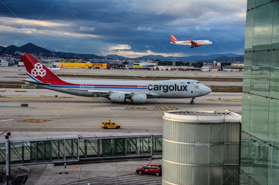 Barcelona El-Prat Airport, Easy Jet landing and Cargolux Boeing 747 taxiing to runway