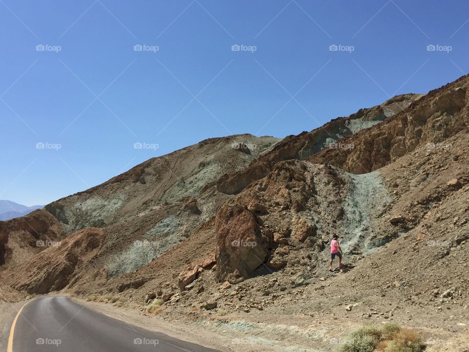 Man climbs the mountain beside the road