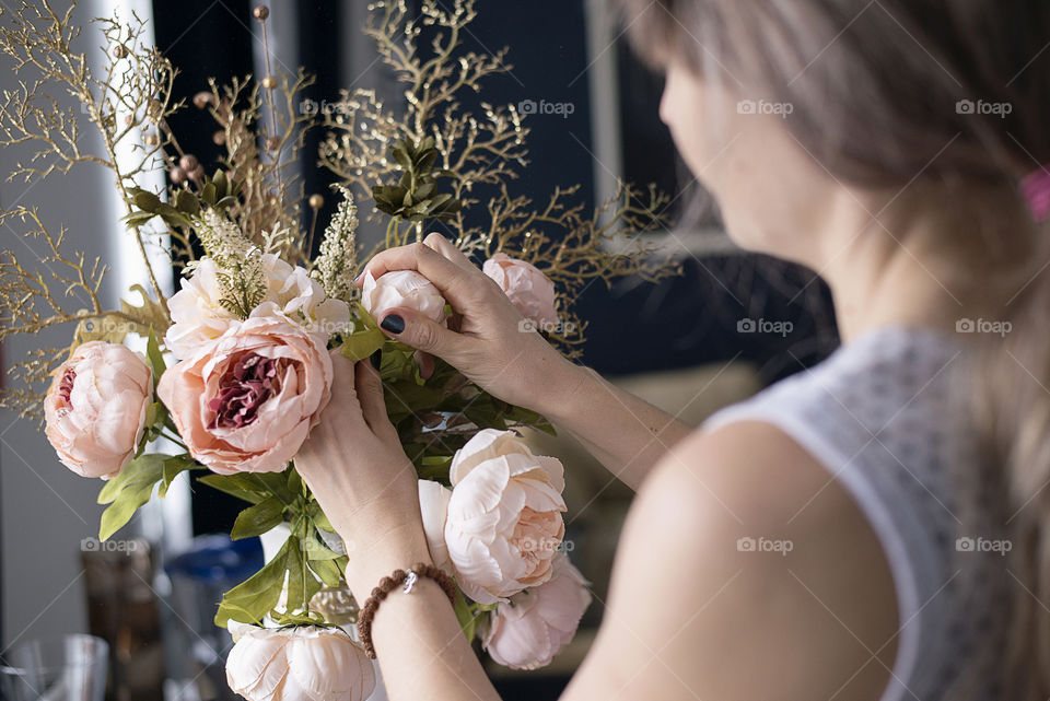 Women adjusting rose in vase