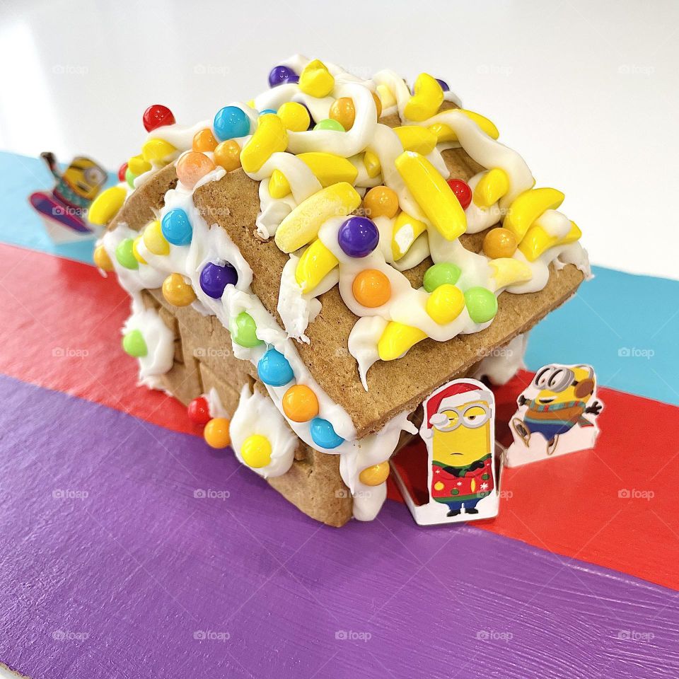 Lots of candy on gingerbread house roof, making crafts with kids, gingerbread houses with Minions, making Minion candy houses 