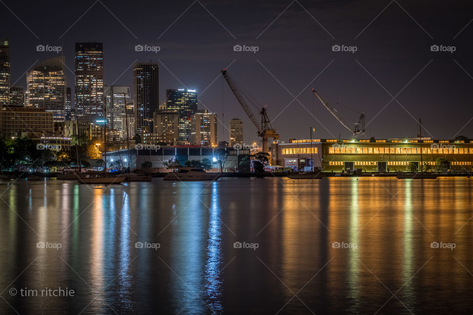 The harbour end of Sydney City and the blue and gold reflections of Garden Island Naval Base 