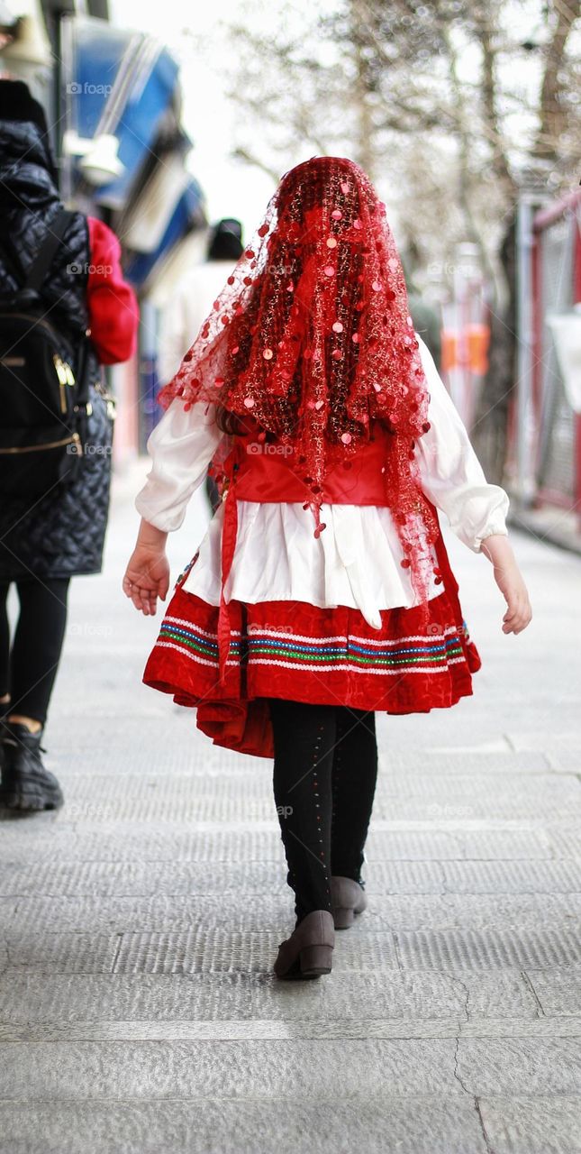 Kurdish gir in the pedestrian with colourful custome which red colour shows energy and dynamic