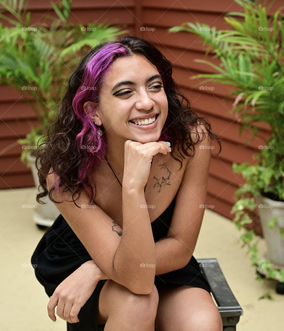 Beautiful young woman, candid portrait outdoors, brunette and pink hair