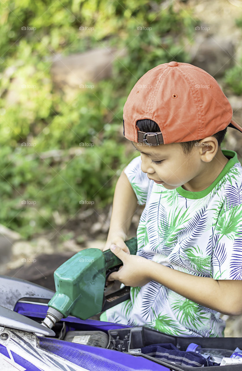 Asian boy filling up fuel into the motorbike