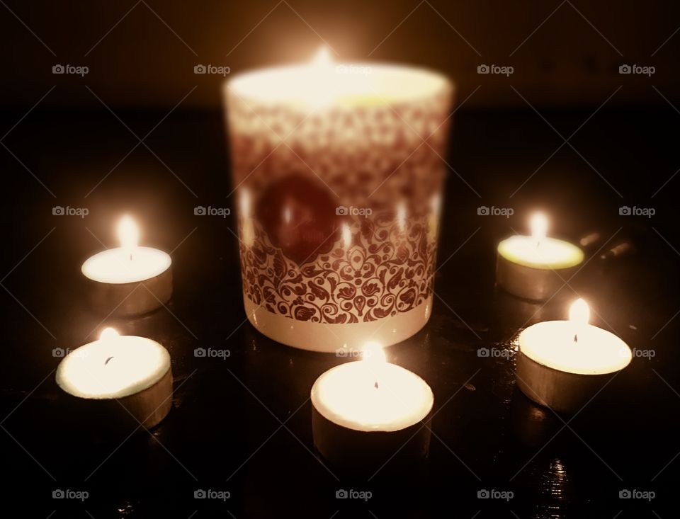Warm bath with candle on table night fire black background 
