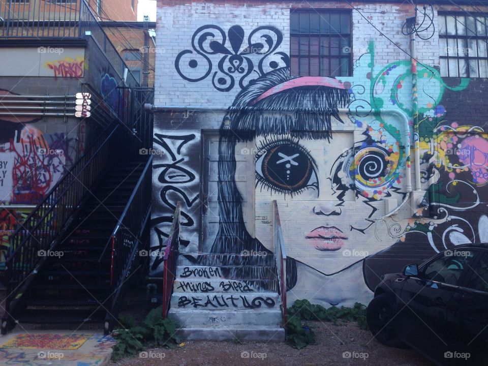 Graffiti artwork of big-eyed girl next to stairwell in Art Alley,  downtown Rapid City, South Dakota 