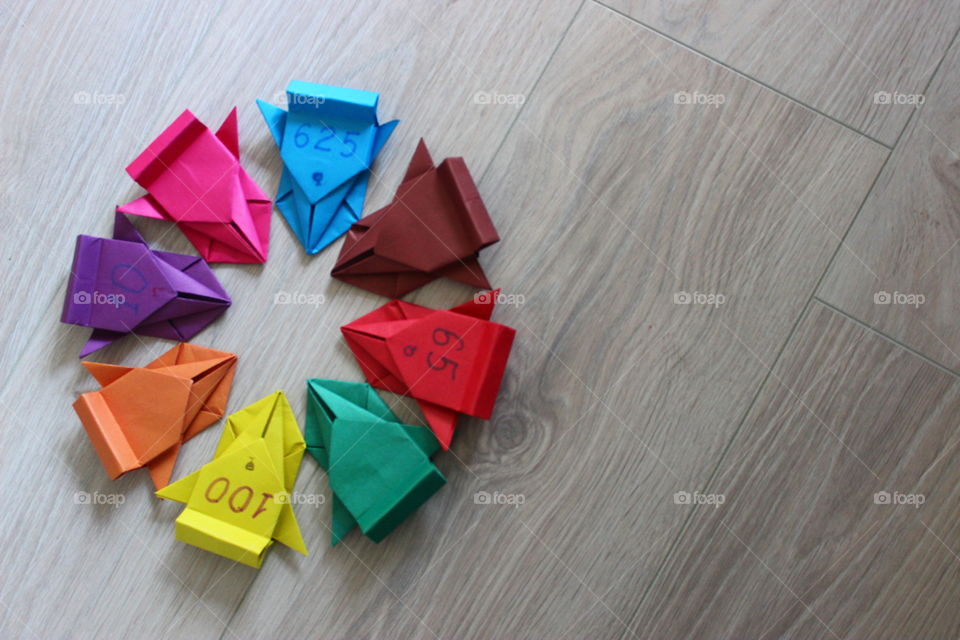 circle of paper rainbow cars on the wooden background