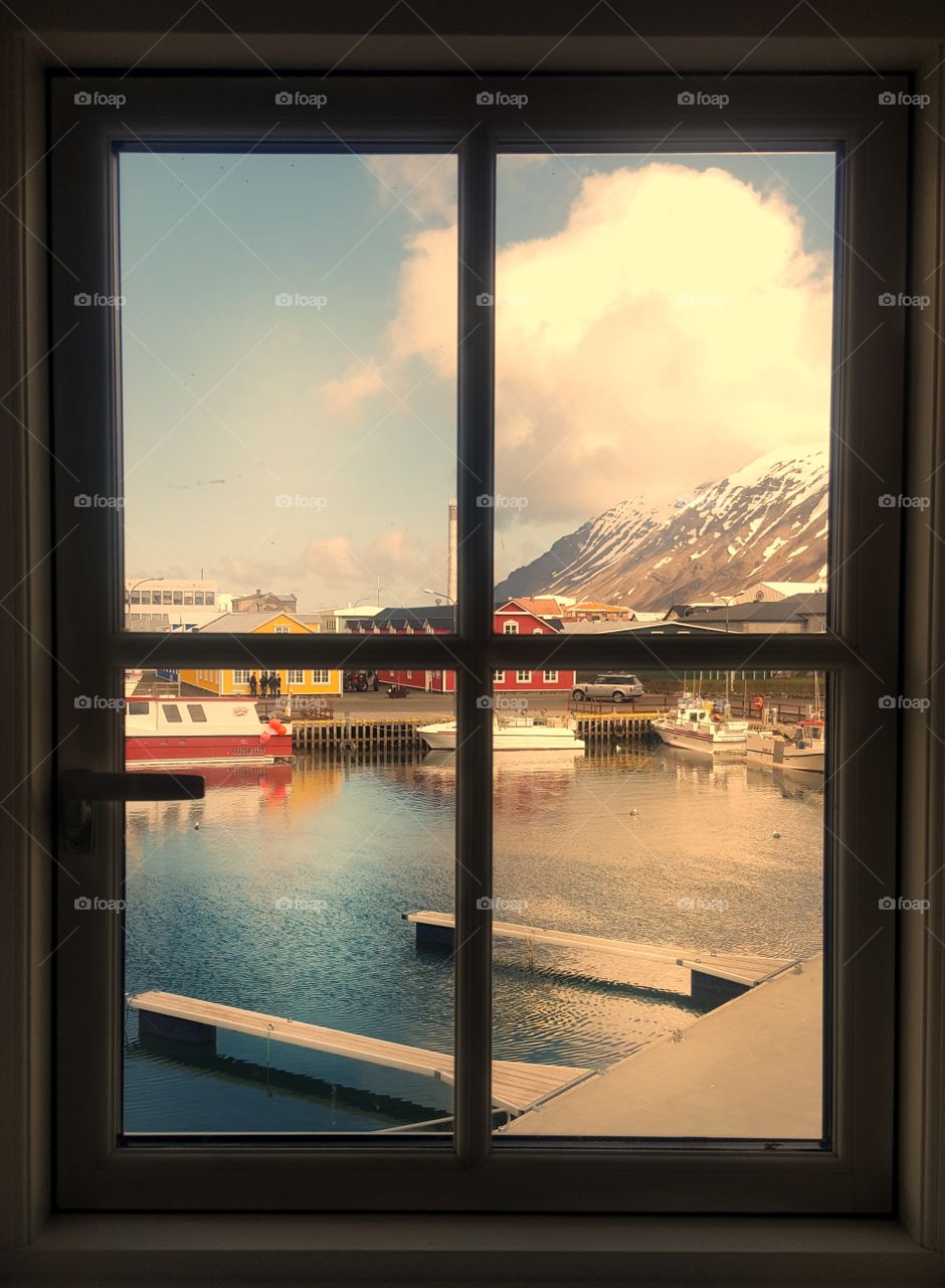 Harbor in a small fishing village in Iceland seen through a window
