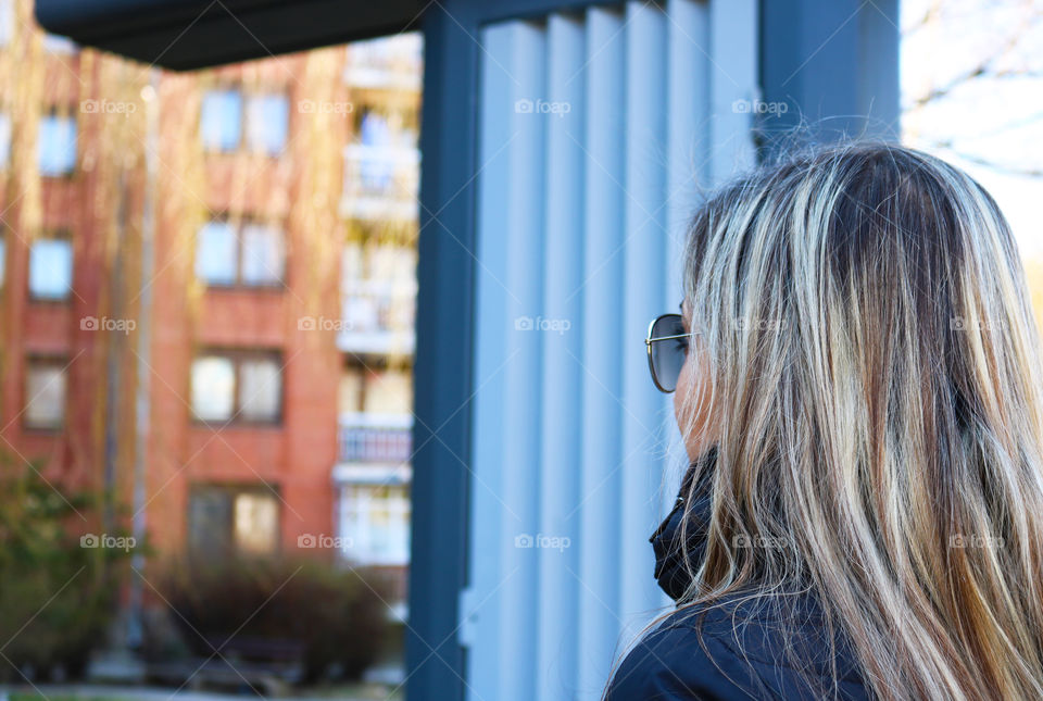 A blond woman watching at the building