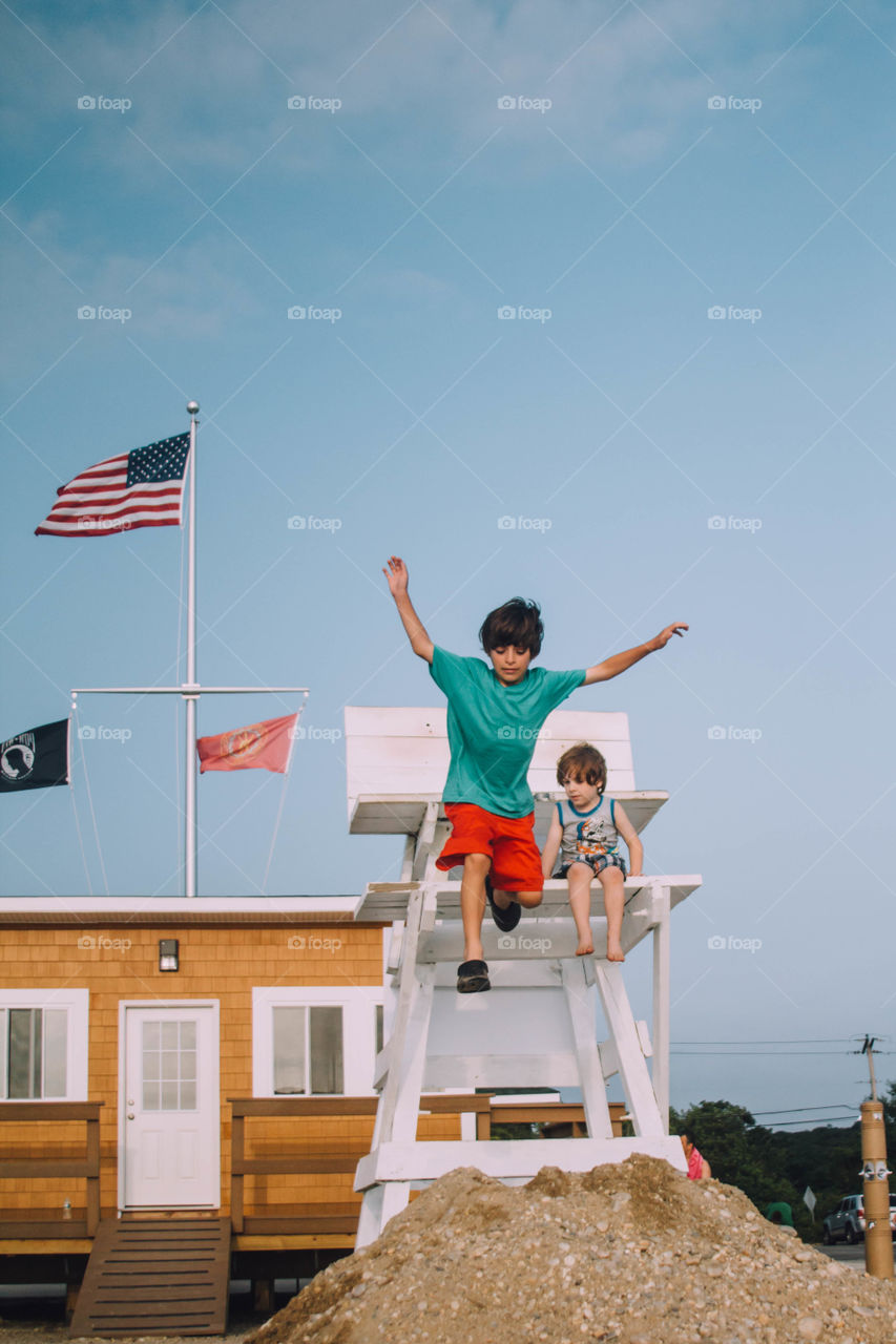 Boy jumping off lifeguard tower