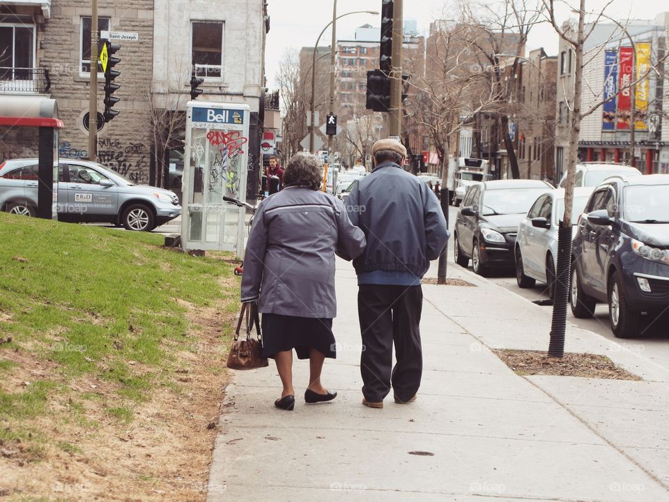 A elderly couple walking arm in arm