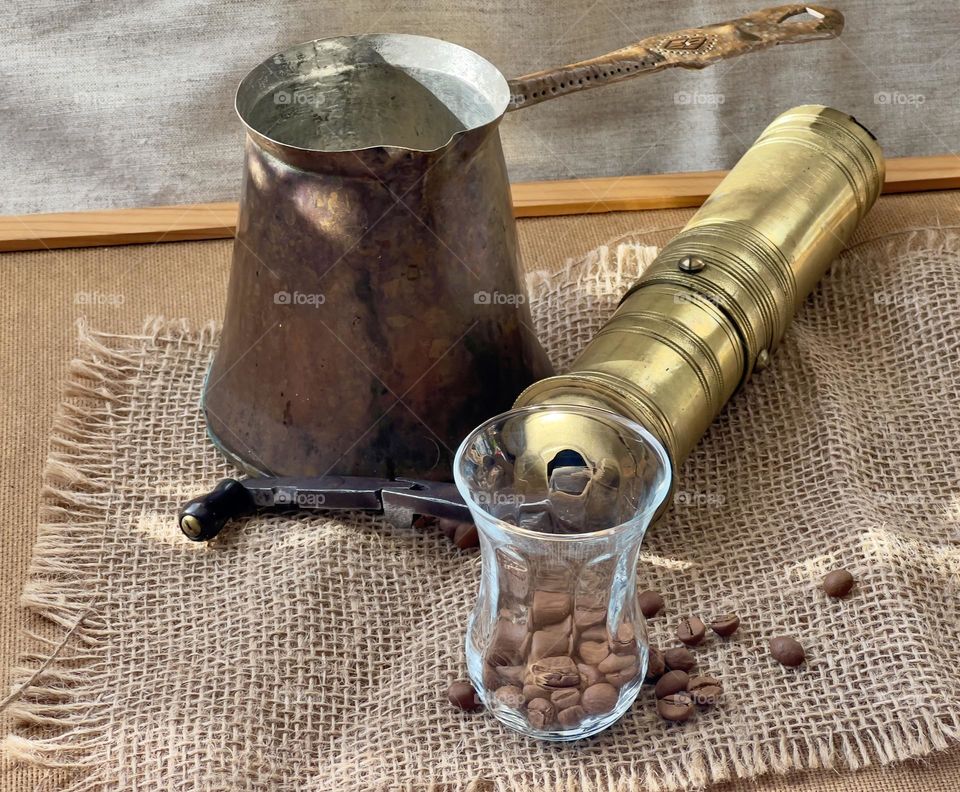 Coffee beans and old coffee grinder and copper pot