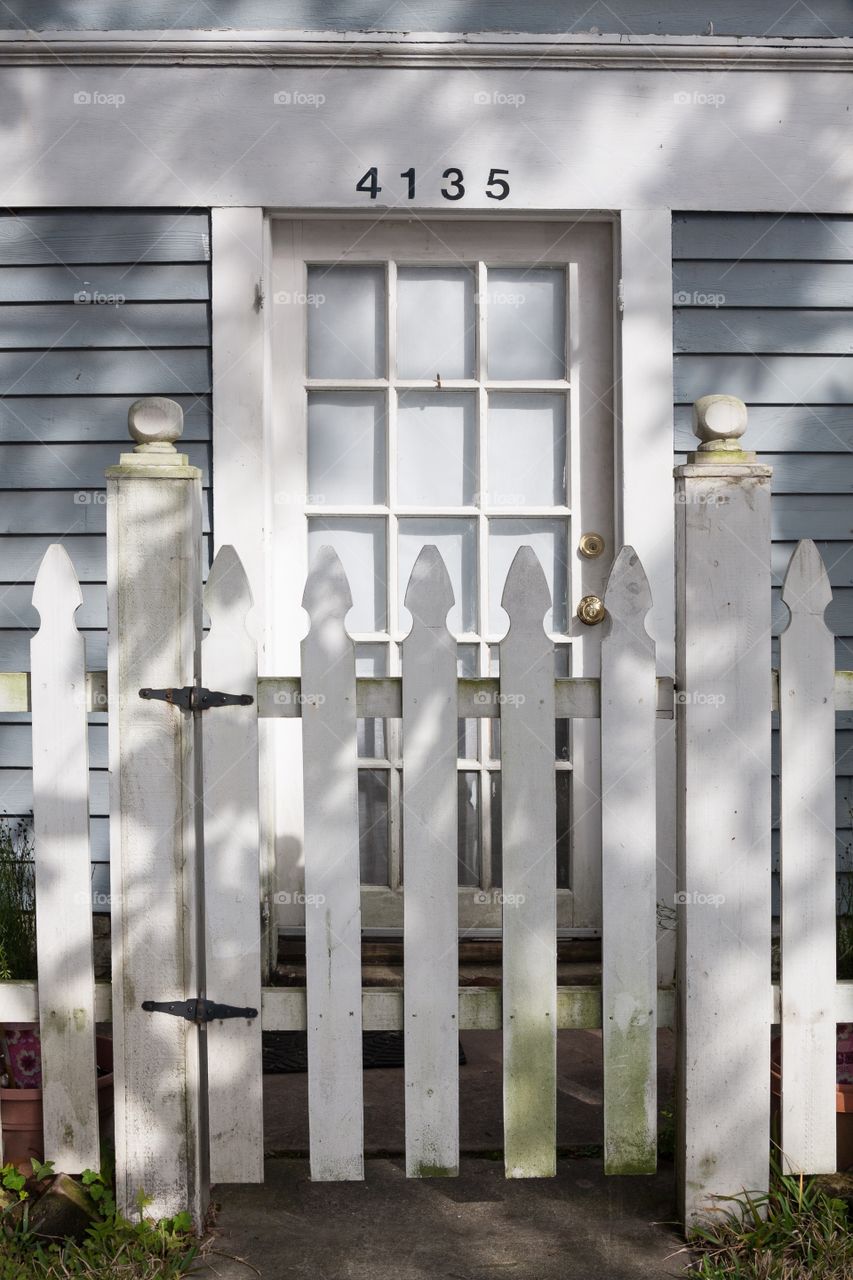 Gray and white door with white fence