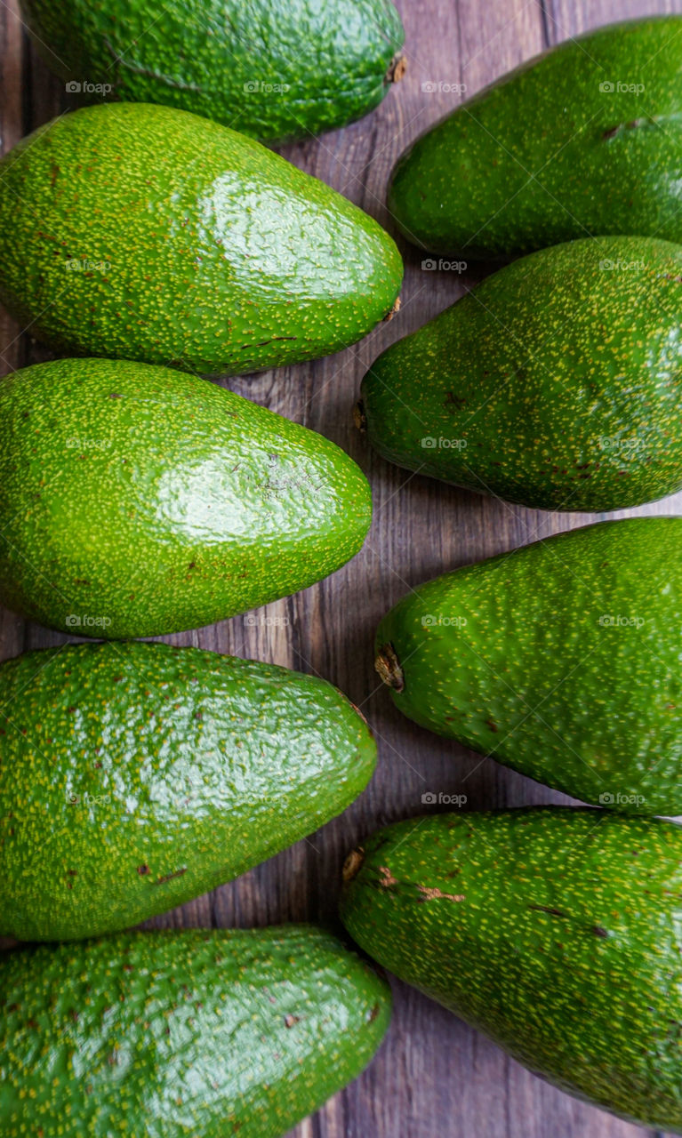 green avocado on wooden background