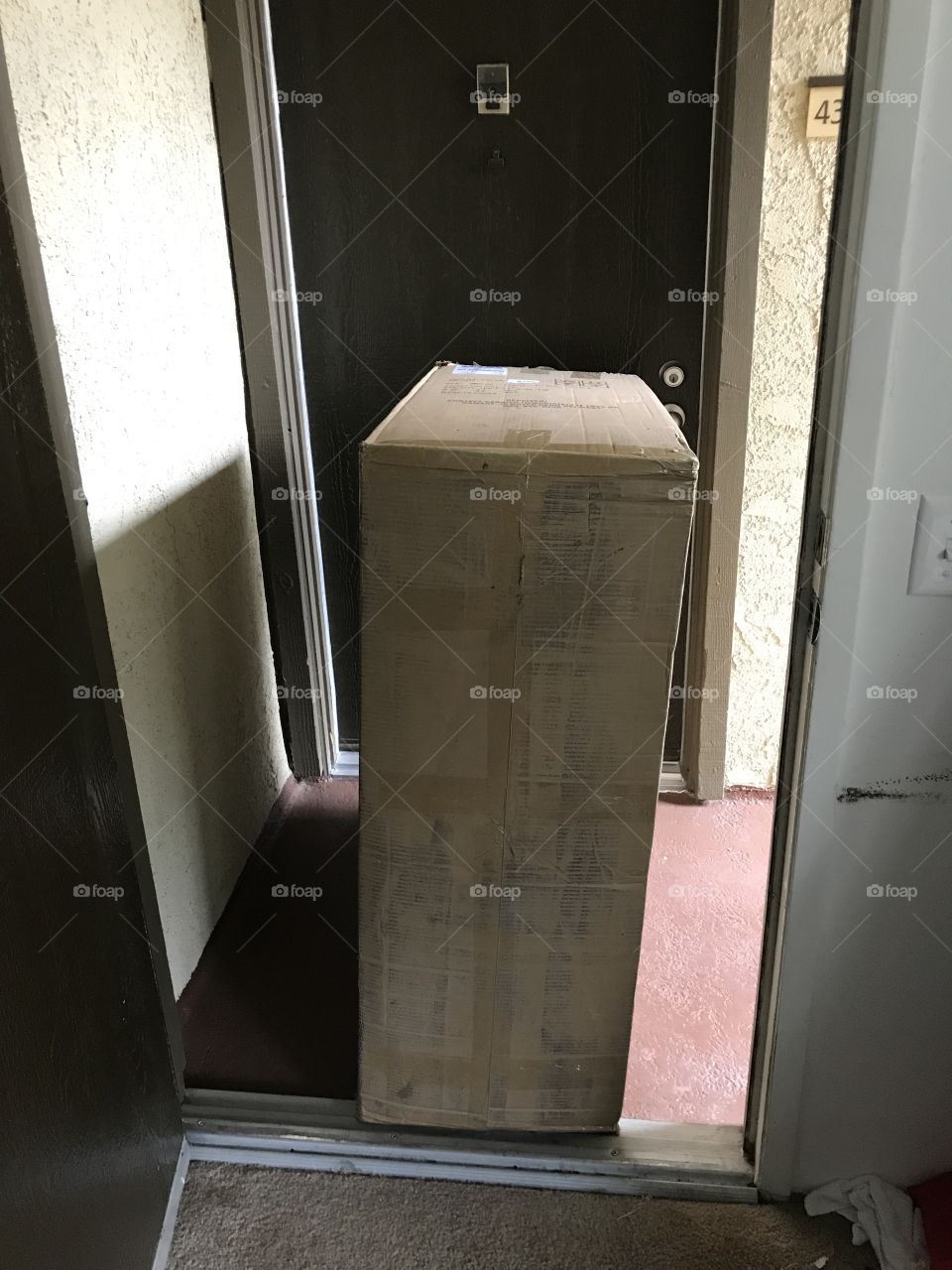 Large box delivery outside on apartment doorstep 