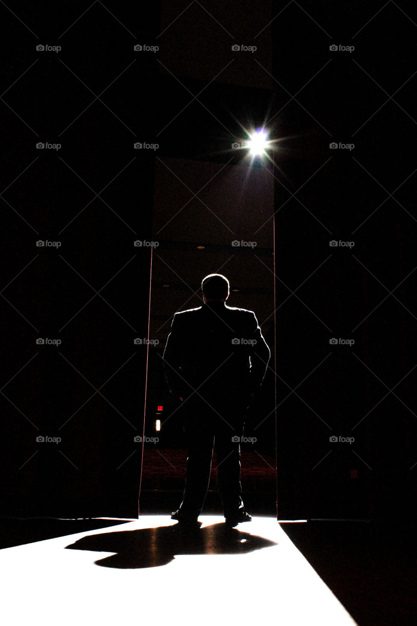 Guy on theater stage in the spotlight.