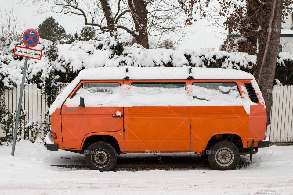 Orange van covered in snow 