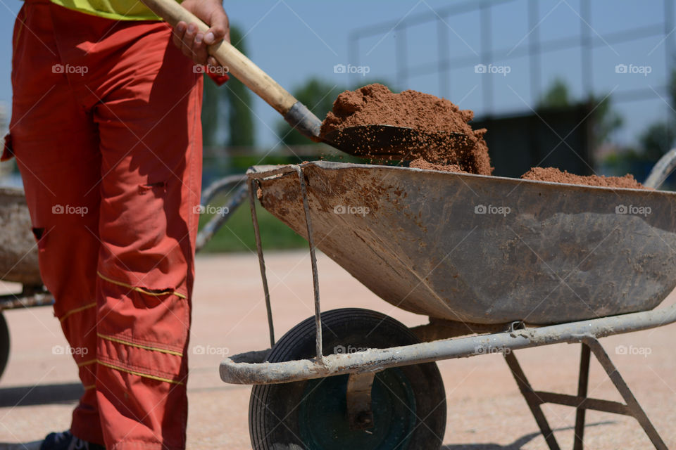 Construction worker shovel. Contruction worker putting sand in mortar cart on construction site in Serbia