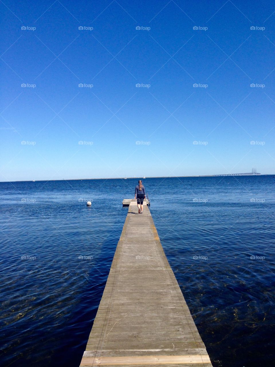 Rear view of woman walking on pier