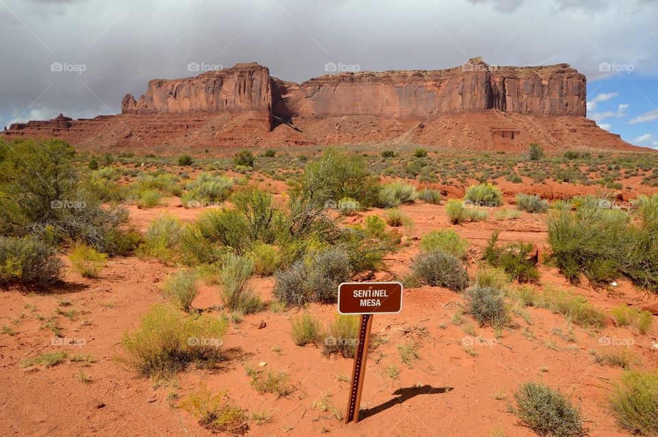 Sentinel Mesa in Monument Valley is covered in rain clouds. 