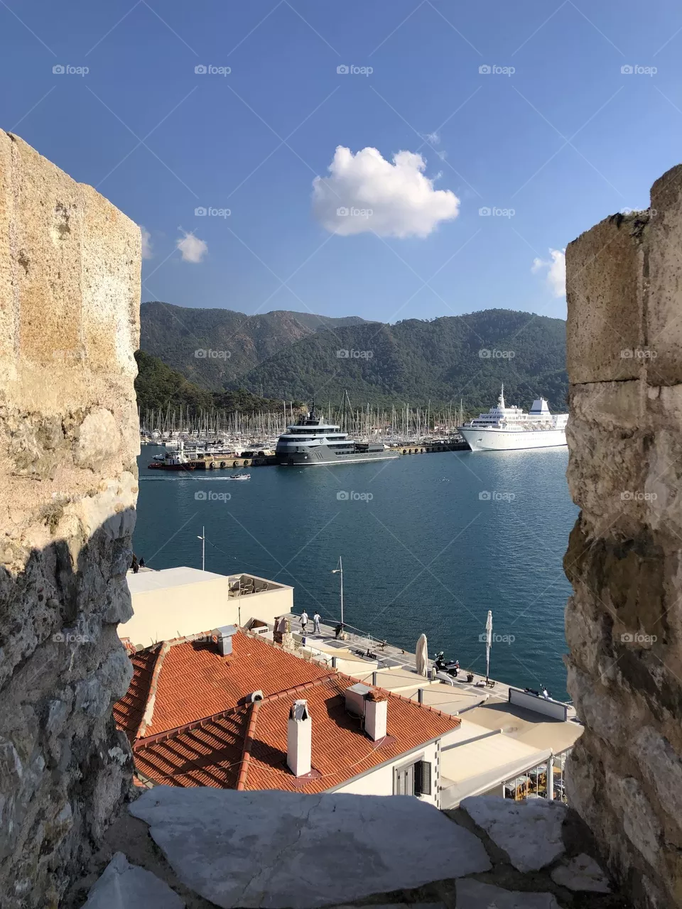 Ancient castle wire, old city roofs, luxury boats, yacht marina, sunny day, sunshine in a blue sky