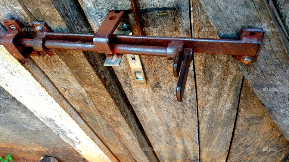 Velha fechadura de ferro, em portão antigo de madeira.