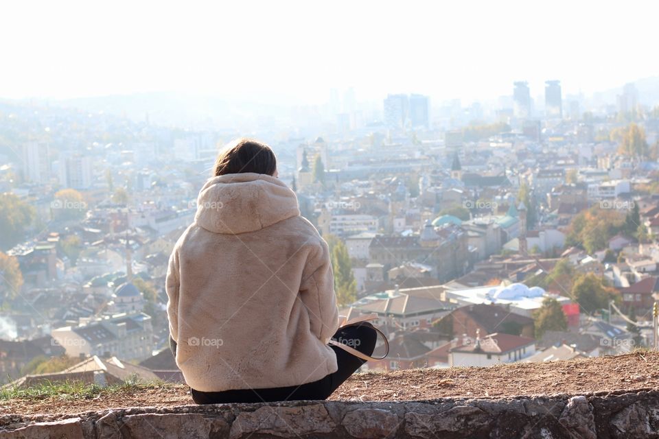 Woman sitting on the top of the city watching the amazing view on Sarajevo