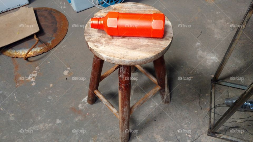 Frasco descartavel em banquinho de madeira.