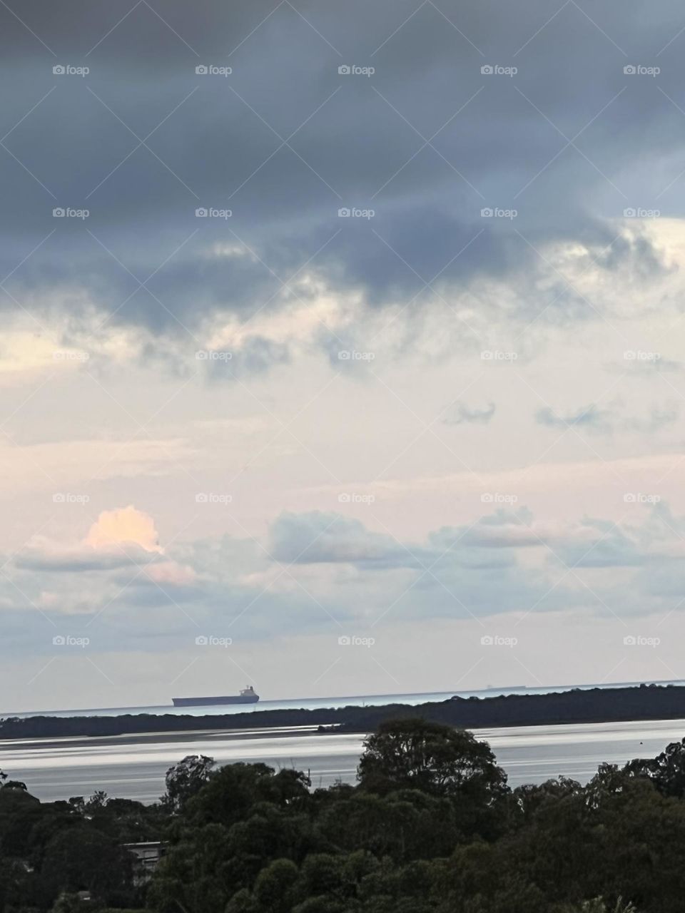 A ship on the ocean anchored waiting for its turn to go into port and load coal at Newcastle on the Central coast of NSW Australia
