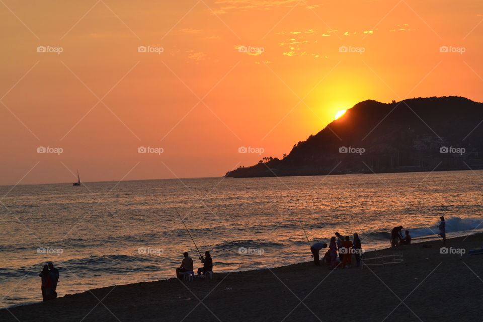 sunset over people on the beach