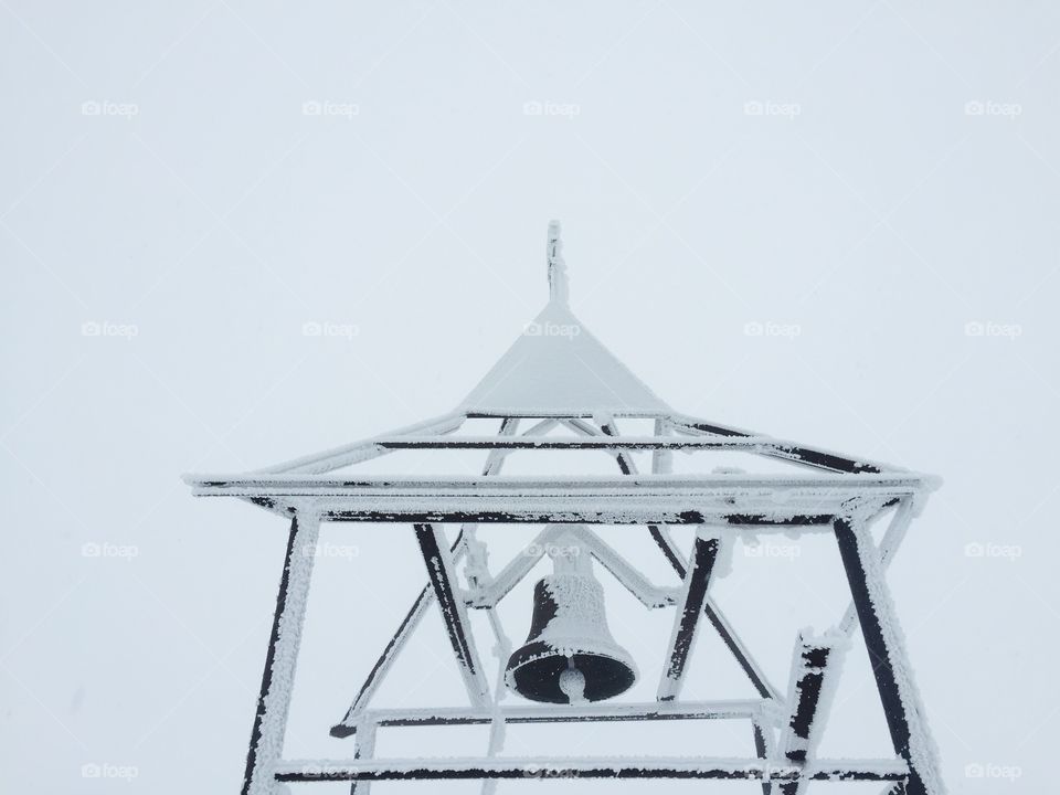 Church bell covered in snow