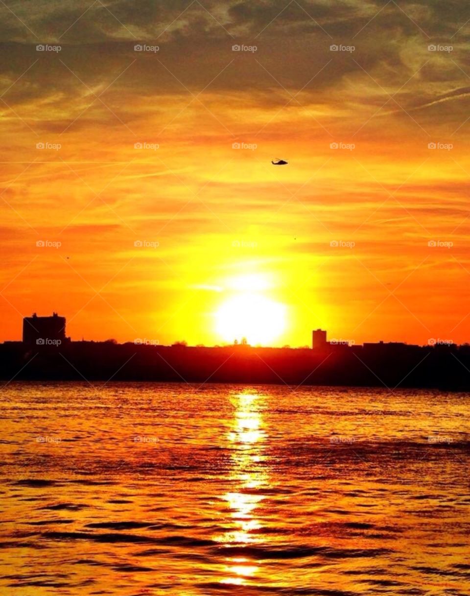 Sunset on the Hudson River, New York City.. Sunset on the Hudson River, New York City. Helicopter silhouette.